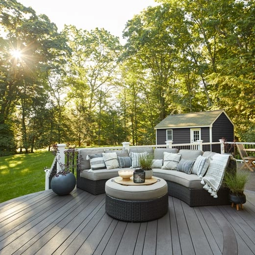 custom-pvc-deck-with-outdoor-living-area-and-potted-plants-with-railing-on-the-back-featuring-big-trees-and-sun-shine-on-the-background-in-outer-banks-nc