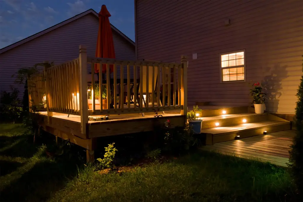 night-scene-on-the-residential-deck-with-lights-on-stairs-with-potted-plants-and-outdoor-living-dining-set-area-in-outer-banks-nc