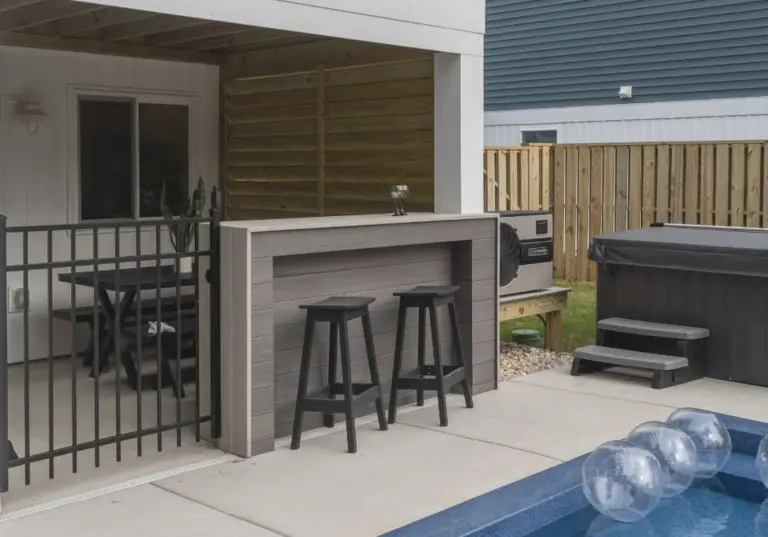 outdoor-bar-beside-the-swimming-pool-with-wooden-privacy-fence-featuring-aircon-and-covered-custom-pool-in-outer-banks-nc