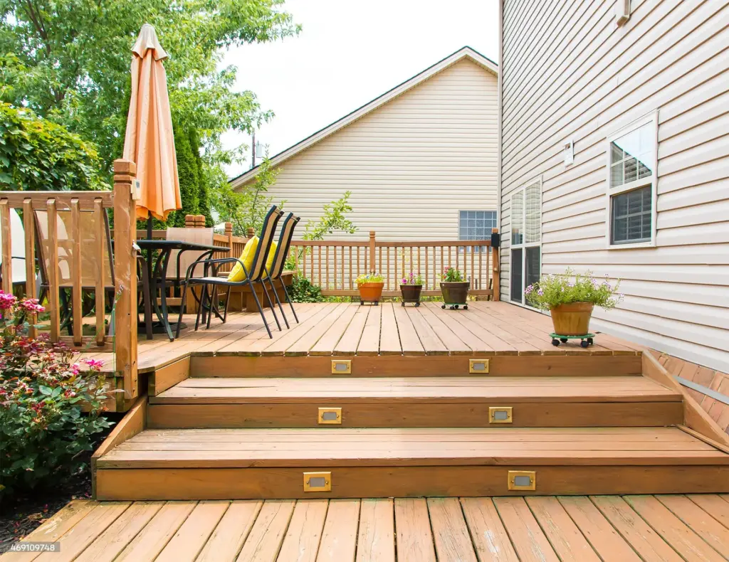 outdoor-residential-deck-with-lights-on-stairs-with-outdoor-living-area-dining-set-with-potted-colorful-plants-in-residential-house-in-outer-banks-nc