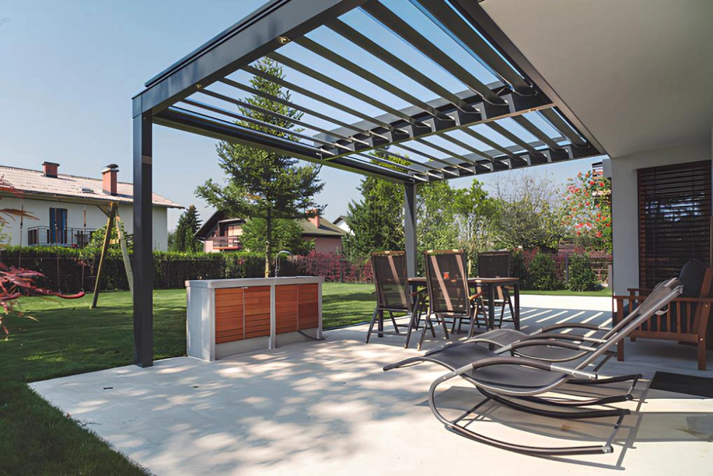 traditional-louvered-pergola-with-flat-roof-and-outdoor-living-dining-set-area-on-the-patio-featuring-beautiful-plants-on-the-lawn-in-outer-banks-nc