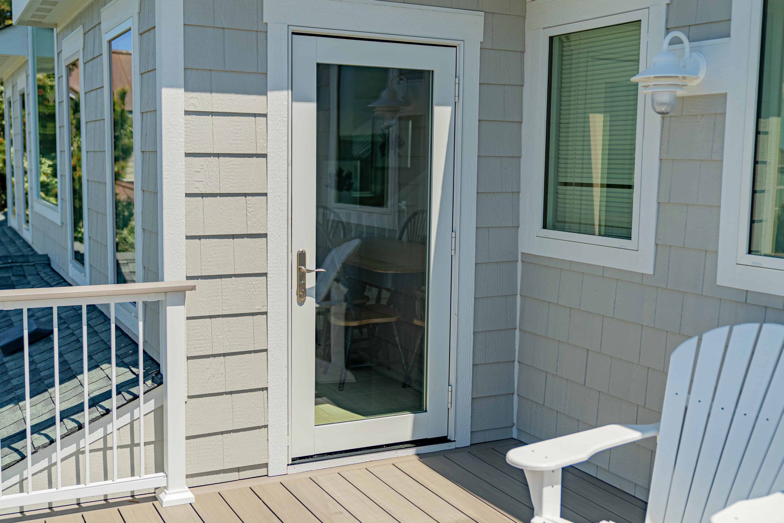 white-trim-door-replacement-on-the-gray-house-with-residential-deck-and-white-balusters-railings-in-outer-banks-nc